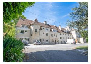 un grande edificio con auto parcheggiate in un parcheggio di Studio calme dans un château au coeur de Caen a Caen