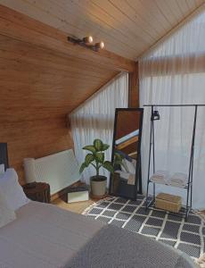 a bedroom with a bed and a mirror and a plant at Cottage Toladi in Kazbegi +41 photos