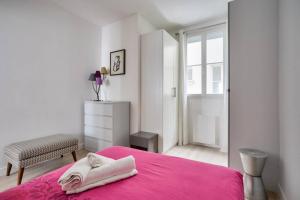 - une chambre blanche avec un lit rose et une chaise dans l'établissement Bel appartement avec lit double dans Paris 15ème, à Paris
