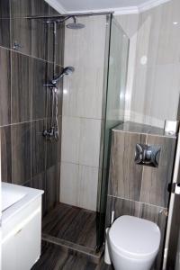 e bagno con doccia, servizi igienici e lavandino. di Rachoni Resort a Skala Rachoniou