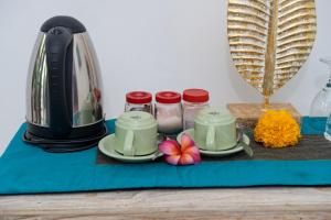 een blauwe tafel met twee kopjes en een broodrooster bij Padma Ubud Retreat in Ubud