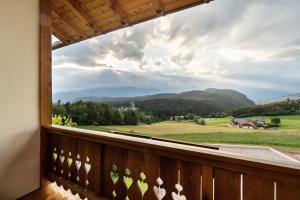 uma varanda com vista para um campo e montanhas em Hof Zerund em Castelrotto