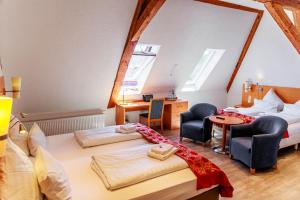 1 Schlafzimmer mit 2 Betten, einem Schreibtisch und Stühlen in der Unterkunft Bodensee-Hotel Kreuz in Uhldingen-Mühlhofen