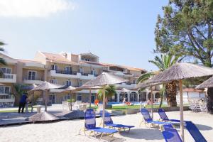 a group of chairs and umbrellas on a beach at Rachoni Resort in Skala Rachoniou