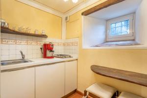Elle comprend une petite cuisine avec un évier et une fenêtre. dans l'établissement Grillo Rosso Taverna, à Molazzana