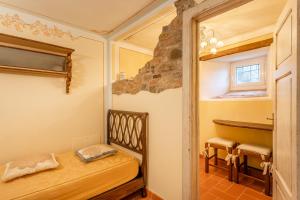 a small bedroom with a bed and a window at Grillo Rosso Taverna in Molazzana