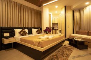 a bedroom with a large bed and a mirror at Seasons Suites in Bangalore