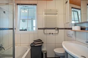 een badkamer met een wastafel, een bad en een toilet bij Chilli Home in Tettnang