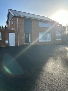 a brick house with a driveway in front of it at Highfield Coach House in Lymington