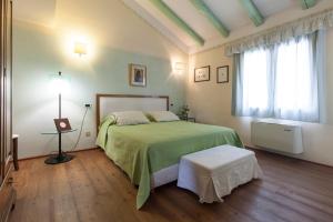 a bedroom with a green bed and a window at COUNTRY HOUSE CASAMIRIAM in Mirano