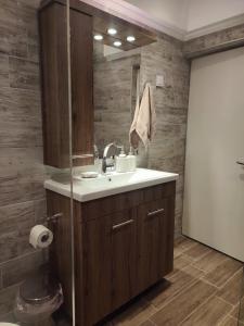 ein Bad mit einem Waschbecken und einem Spiegel in der Unterkunft ALICE'S ARt HOUSE in Kavala