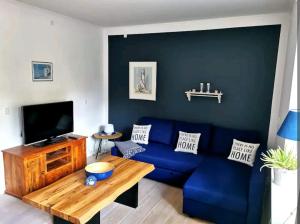 a living room with a blue couch and a wooden table at Birkevang holiday apartment in idyllic countryside in Faxe