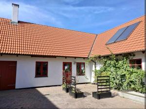 a house with an orange roof with solar panels on it at Birkevang holiday apartment in idyllic countryside in Faxe
