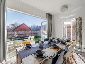 a dining room with a long table and a large window at Number Fifty-Eight in Belper