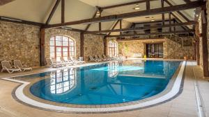 a large indoor pool with blue water in a building at Pałac Wojanów in Wojanów