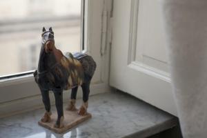 una estatua de un caballo de madera sentada en una mesa junto a una ventana en Residenze Torinesi, en Turín