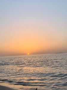 - un coucher de soleil sur l'océan avec une personne sur la plage dans l'établissement AlSultan Apartments, à Umm Lajj