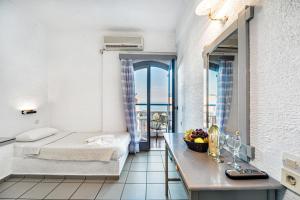 een slaapkamer met een bed en een tafel met een wastafel bij Hotel Iro in Chersonissos
