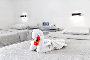a white towel swan sitting on the floor in a bedroom at Hotel Iro in Hersonissos
