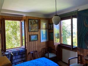 Schlafzimmer mit Holzwänden und -fenstern sowie einem Bett in der Unterkunft La casetta del Professore in Olgiasca