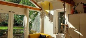 een woonkamer met een raam en een gele stoel bij Natuurhuisje Heerlijkheid Beek in Berg en Dal