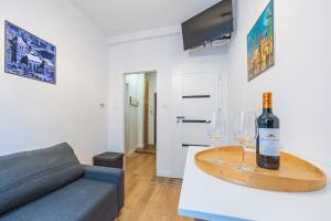 a living room with a bottle of wine and two wine glasses at Hello Apartments Studio Sw Ducha in Gdańsk