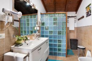 baño con lavabo y ducha con azulejos azules en Finca Los Angeles, en San Juan de la Rambla