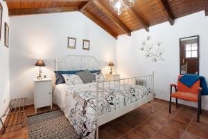 um quarto com uma cama e uma cadeira vermelha em Finca Los Angeles em San Juan de la Rambla