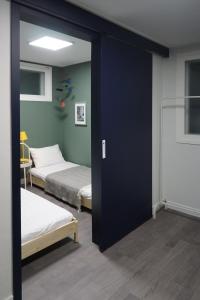 首爾的住宿－Mapo 2bedroom house，带两张床和滑动玻璃门的客房