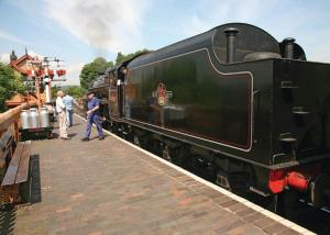 a group of people standing next to a black train at Wigley Orchard in Clifton upon Teme