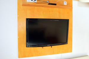 TV de pantalla plana colgada en una pared de madera en Kleine einfache Ferienwohnung in malerischer Umgebung Salzburgs en Koppl