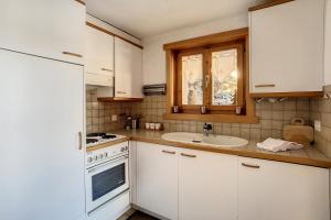 a kitchen with white cabinets and a sink at Bocage 3 in Verbier