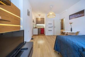 a living room with a bed and a kitchen at Hello Apartments Modern Studio Sw Ducha in Gdańsk