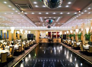 a dining hall with tables and chairs in a restaurant at Hotel Iskierka Business & Spa in Mielec