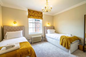 Un dormitorio con dos camas y una ventana. en Clifford's Townhouse, en York