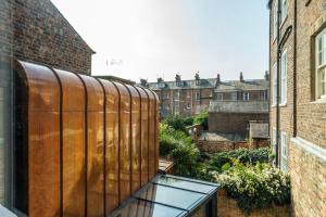 balcón con mesa de cristal y algunos edificios en Clifford's Townhouse, en York