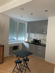 een keuken met een tafel en 2 krukken bij Apt 2 chambres au coeur de Uccle in Brussel