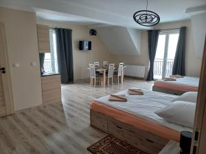 sypialnia z 2 łóżkami, stołem i krzesłami w obiekcie Apartamenty Na Rozstaju w Kluszkowcach
