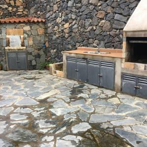 a stone patio with a sink and a stone wall at Casa Rural Las Avestruces in Agulo