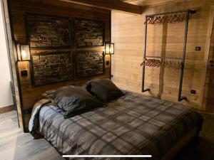 1 dormitorio con 1 cama con pared de madera en Le Paradis de Marie, en Gérardmer