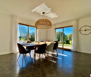 une salle à manger avec une table, des chaises et une horloge dans l'établissement Maison TY LAOUEN, à Locoal-Mendon