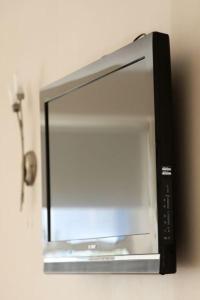 a television hanging on a wall with a mirror at Desota House Bed and Breakfast in Galway