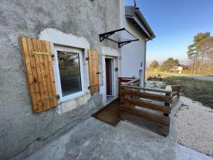 a building with a window and a wooden fence at La Ferme aux Diligences in Neydens