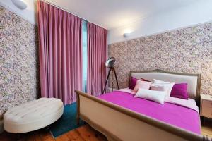 Luxury Artist Residence in Central London في لندن: غرفة نوم مع سرير كبير مع ملاءات أرجوانية