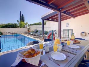 卡尼索Villa Garajau by LovelyStay的游泳池旁的餐桌,供应食物和饮料