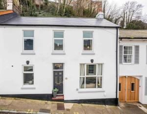 a white house with a black door at Pittman Cottage in Torquay