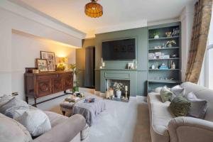 a living room with two couches and a fireplace at Pittman Cottage in Torquay