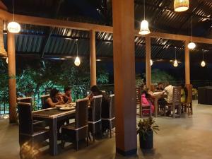 um grupo de pessoas sentadas em mesas em um restaurante em Relax Lake View Resort em Kataragama