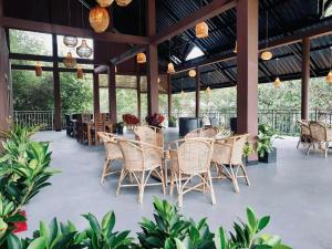 um pátio com cadeiras de vime, mesas e plantas em Relax Lake View Resort em Kataragama