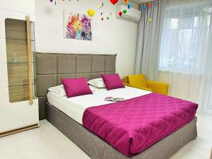 ヴァルナ・シティにあるTevi Apartmentsのベッドルーム1室(ピンクの毛布付きの大型ベッド1台付)